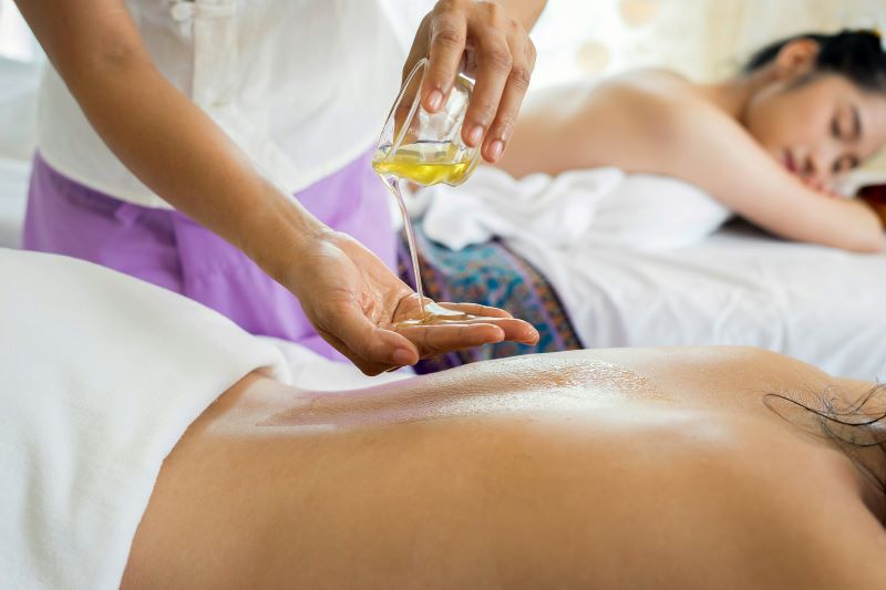 Pouring massage oil into hand for back massage